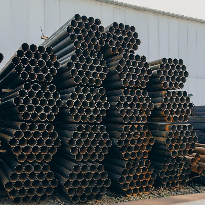 steel metal pipes piled on to of each other ready to be cut with a laser